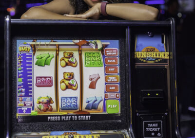 A woman posing behind a slot machine